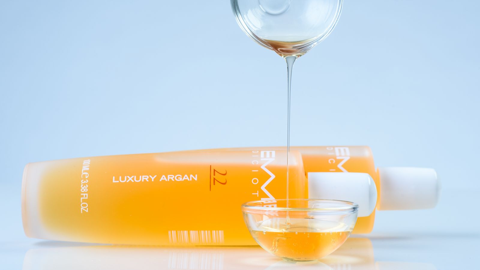 Argan oil being poured from a bottle for hair care