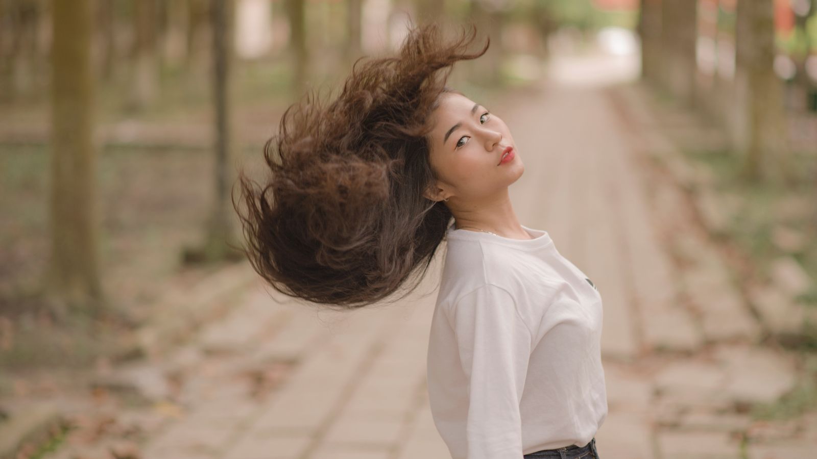 Woman flipping full bouncy hair achieved on a budget