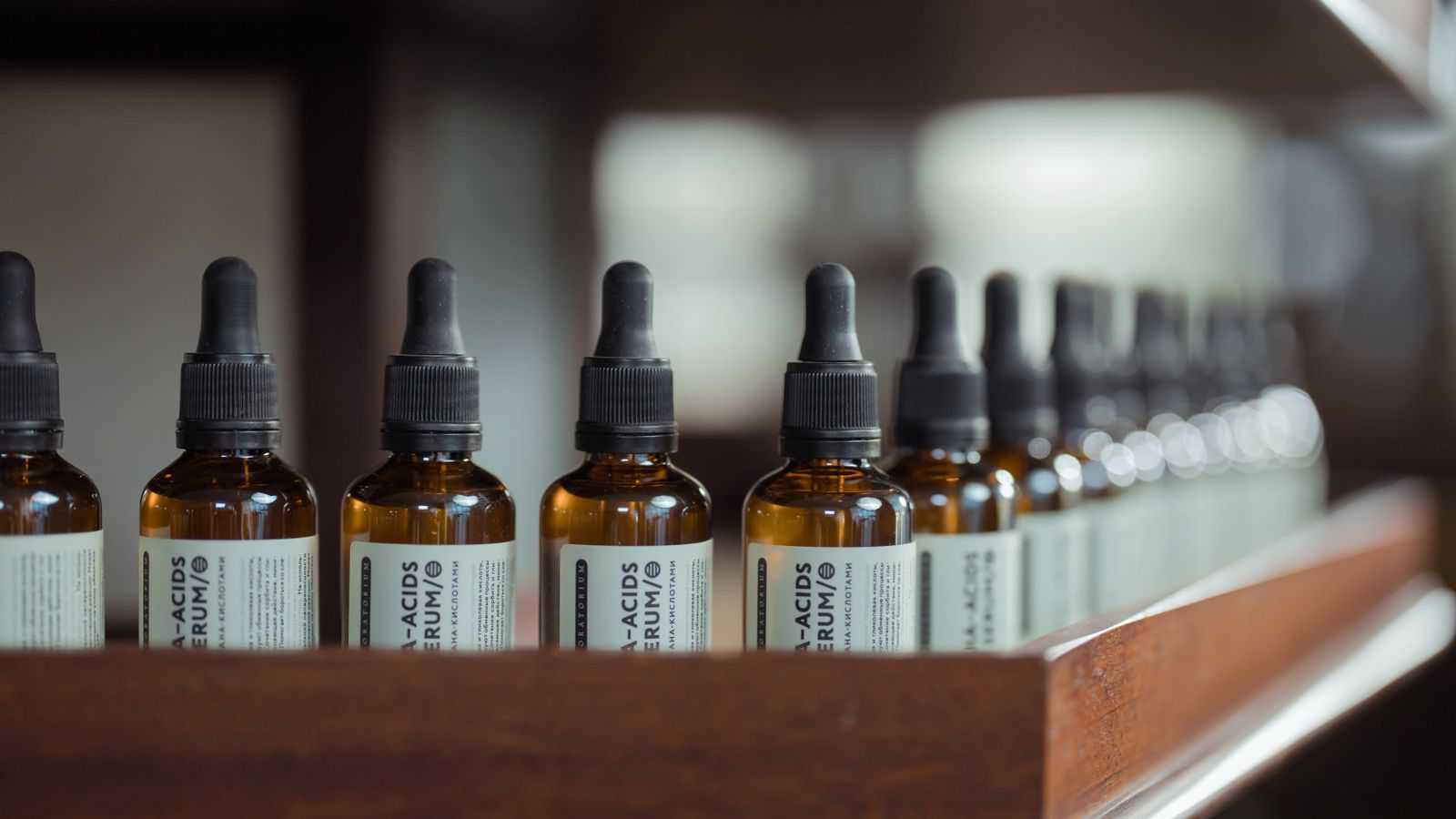 Row of hair growth serum bottles with dropper caps lined up on a shelf