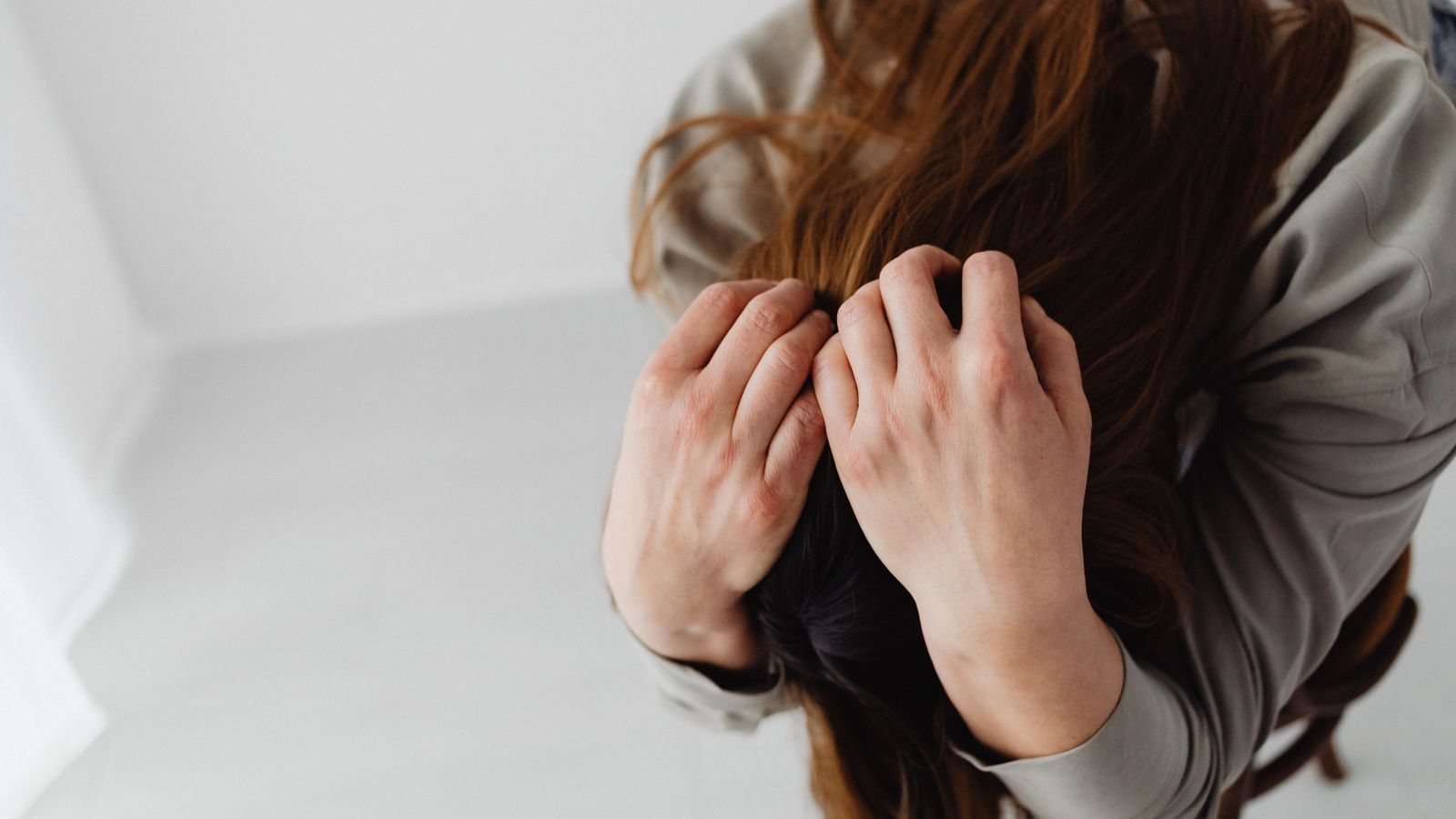 Woman holding her head, working out the dry scalp vs dandruff question