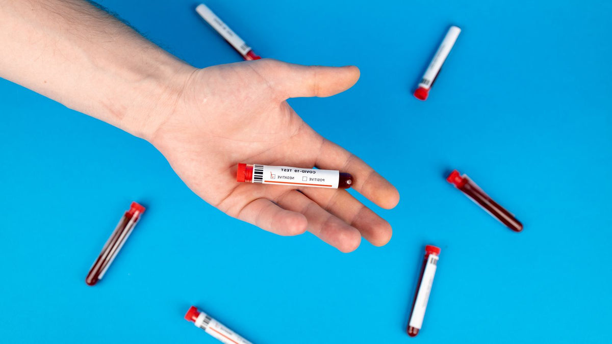 Hand holding a blood sample vial used to check ferritin levels