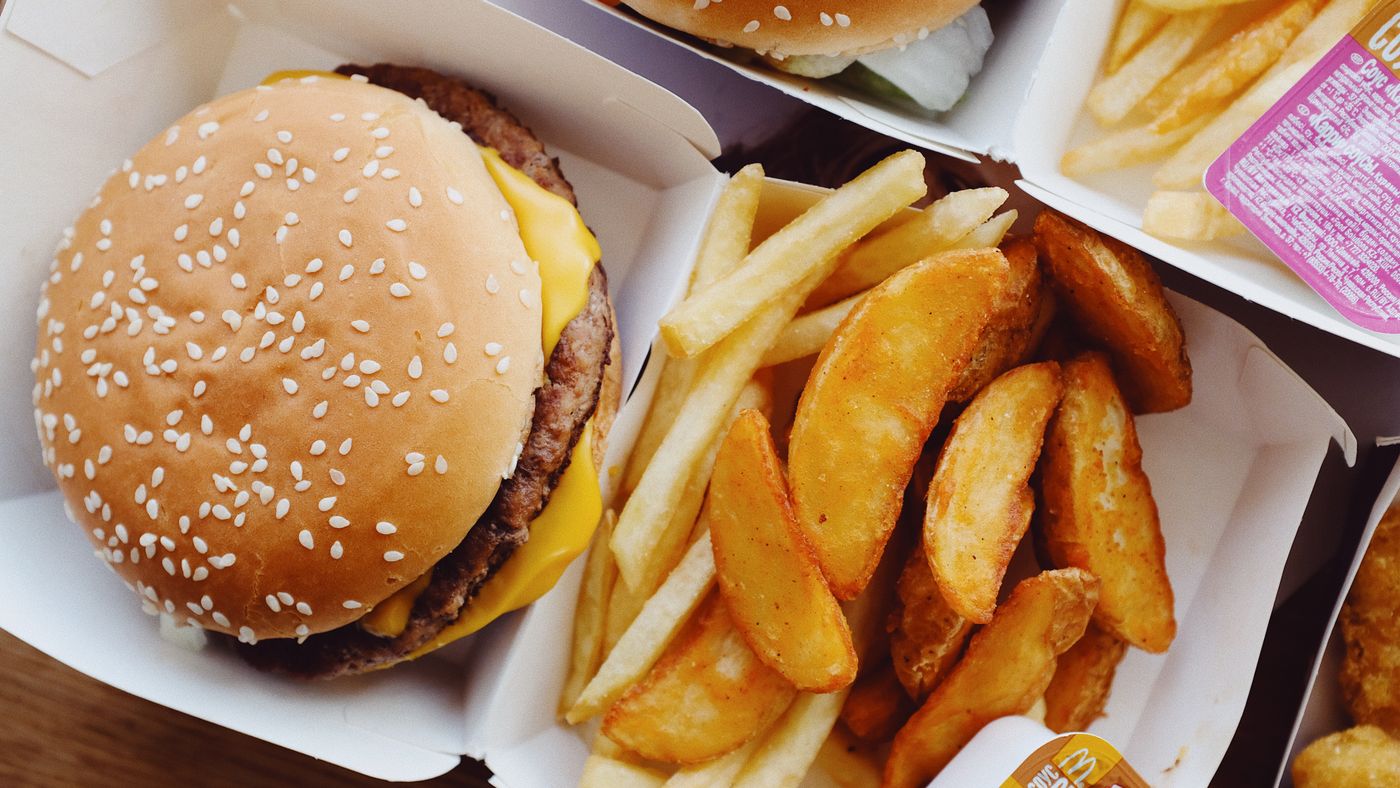 Burgers and fries on a table, ultra processed foods bad for your liver in excess