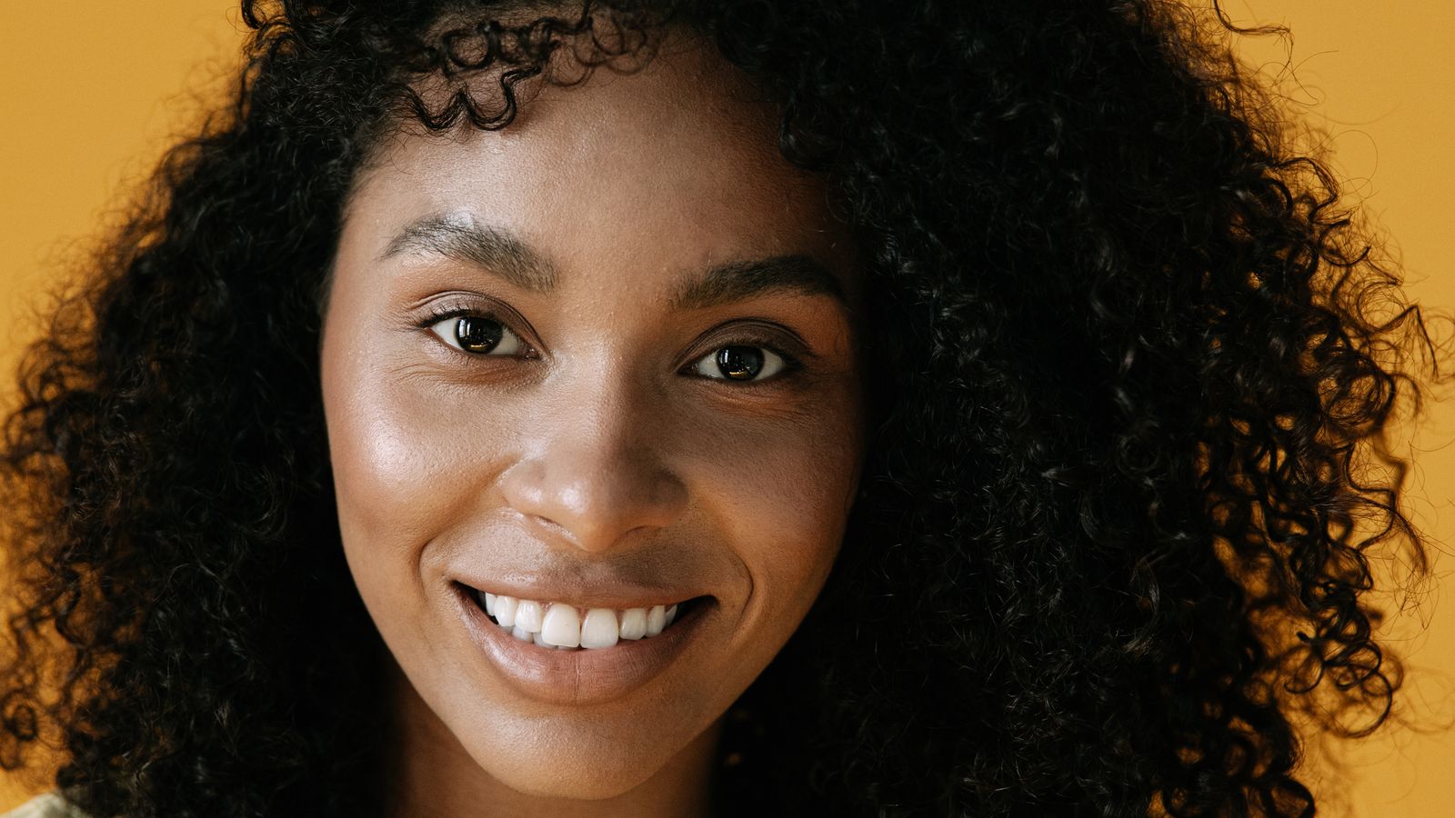 Smiling woman with full healthy hair after using a hair growth serum