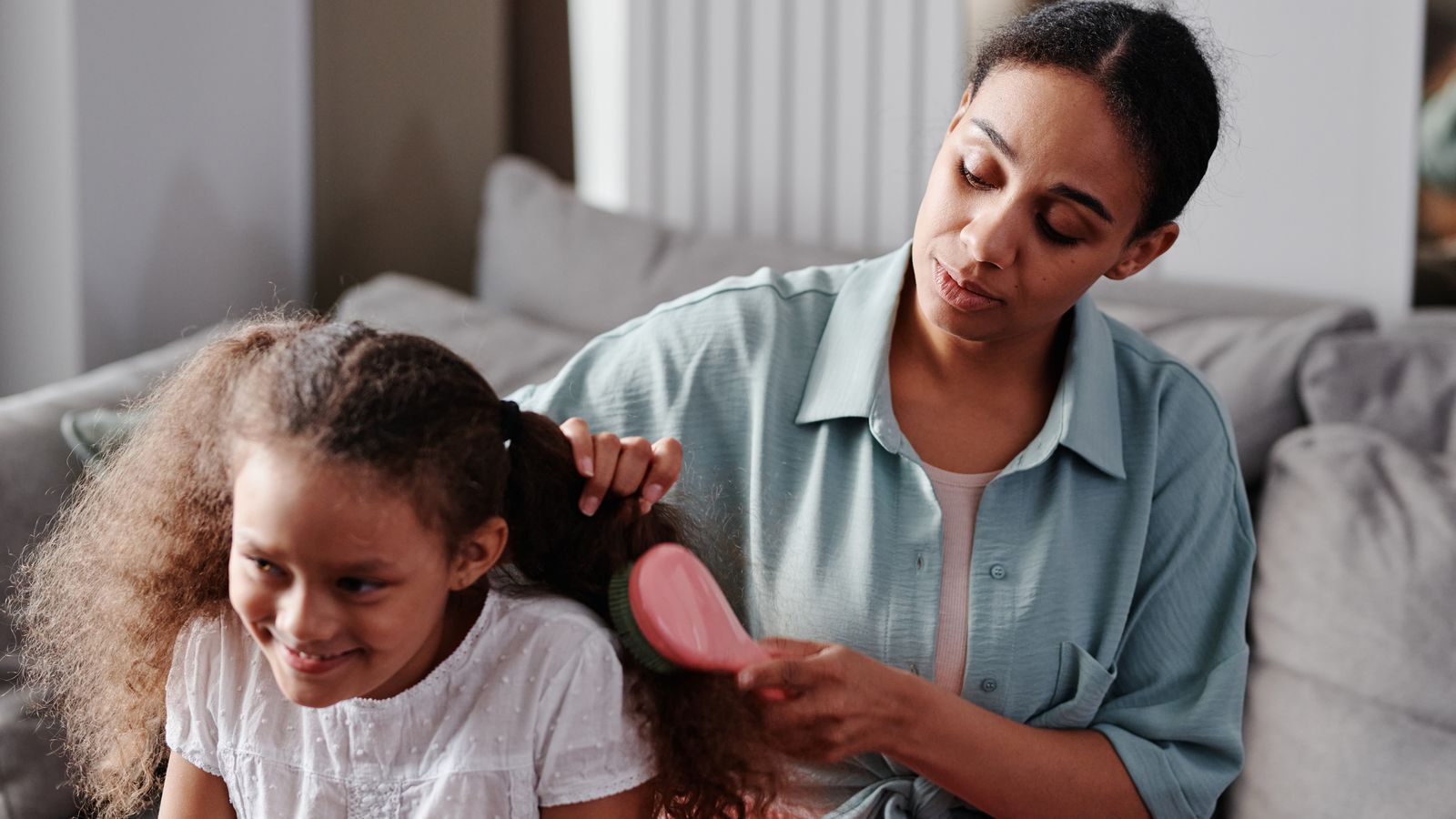 Mother gently caring for her child's hair while understanding hair loss in children