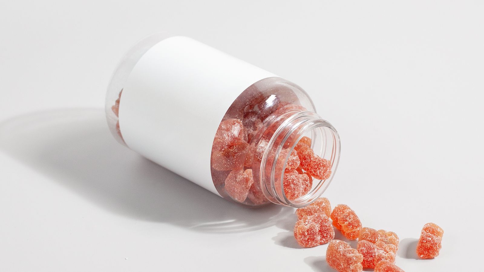Gummy hair vitamins spilling from a bottle, biotin and zinc for the maintenance of normal hair