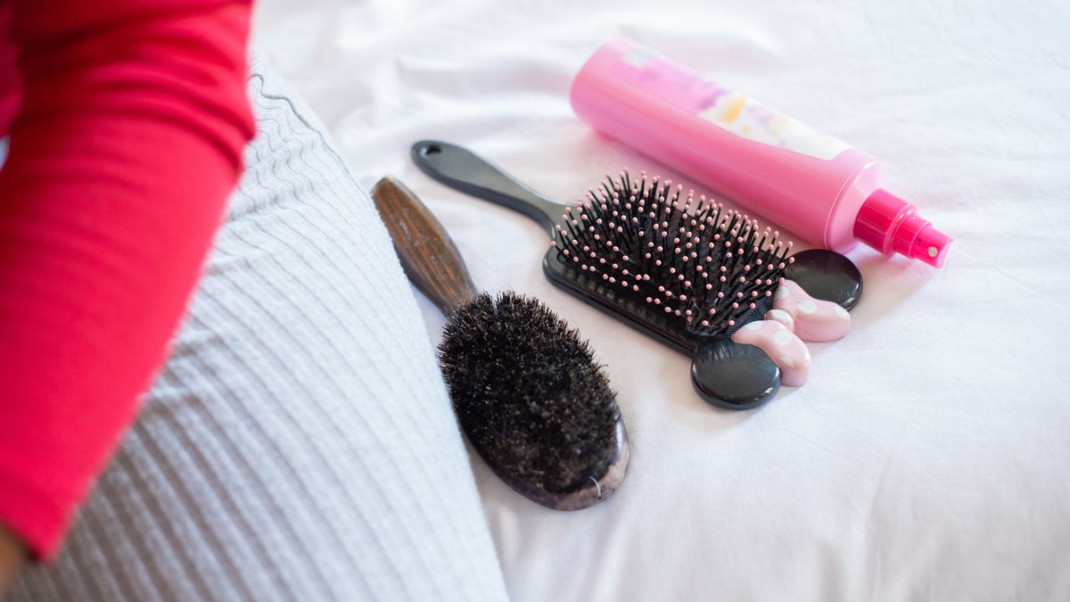 Hairbrush holding loose strands, the everyday question of how much hair shedding is normal