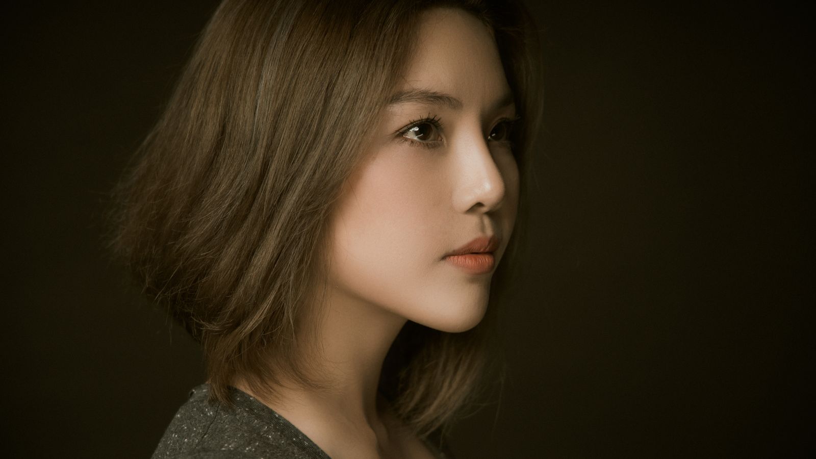 Side profile of a woman with a deep side parting, part of how to hide thinning hair front woman styling