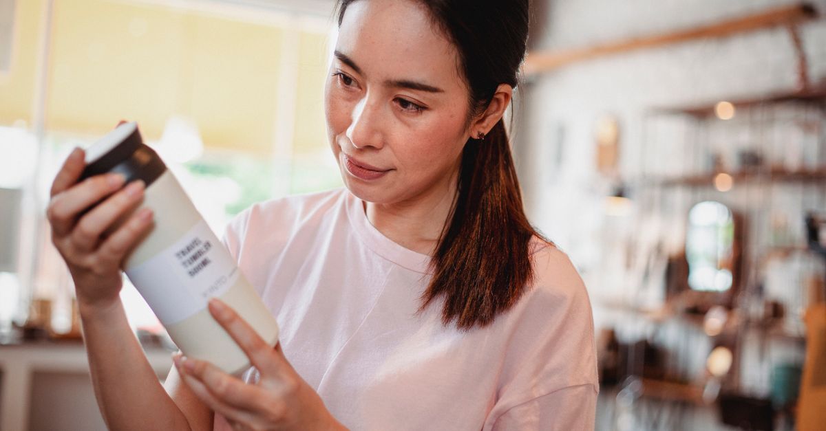 A shopper reading the back of a bottle, showing how to read a hair product label