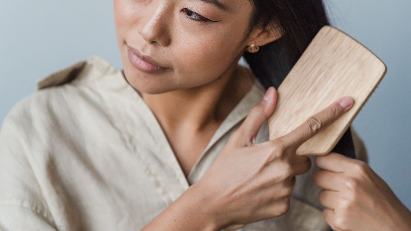 Woman brushing healthy hair after stopping minoxidil