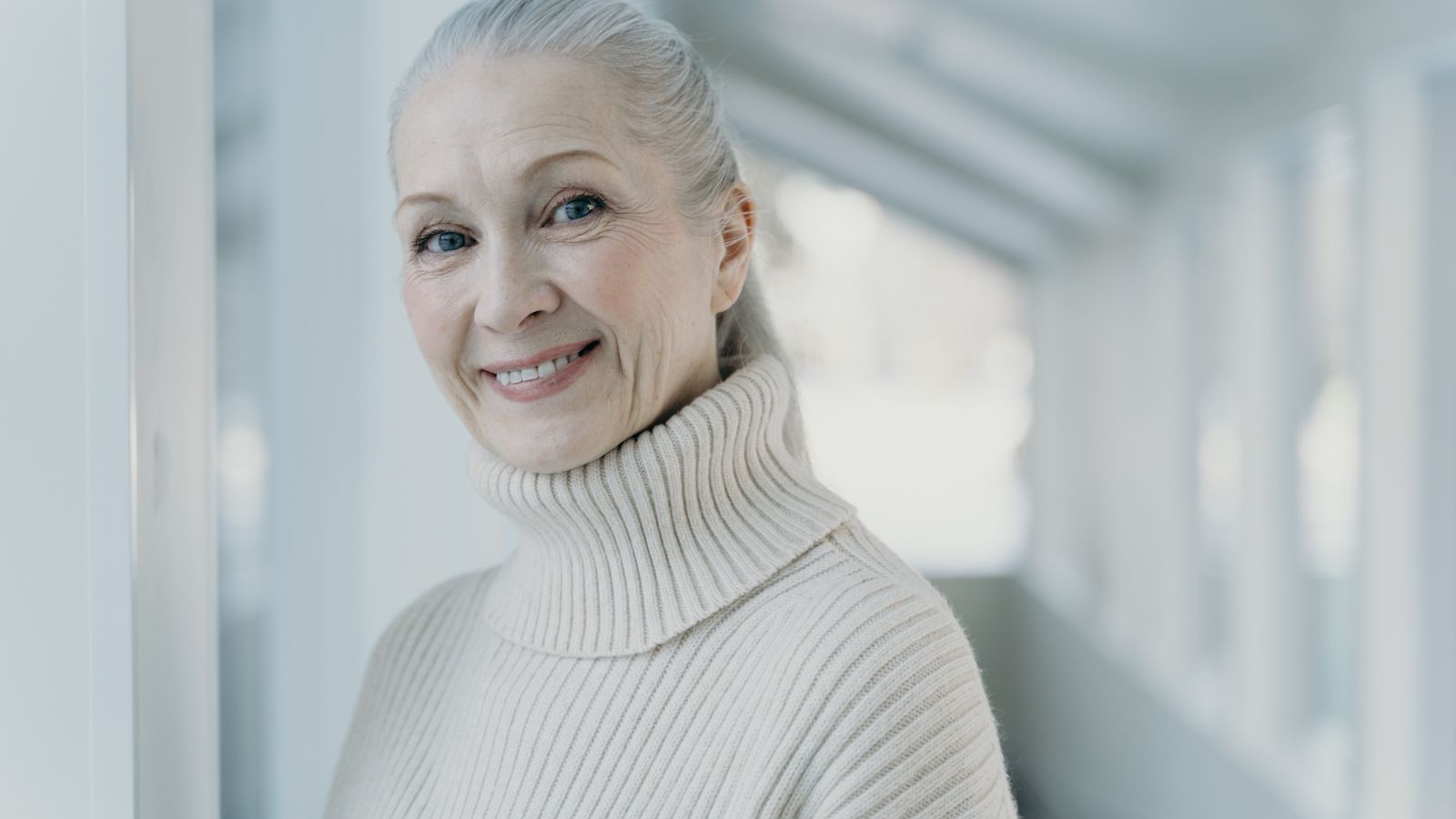 Smiling woman with grey hair, the life stage when HRT and hair density questions usually arise