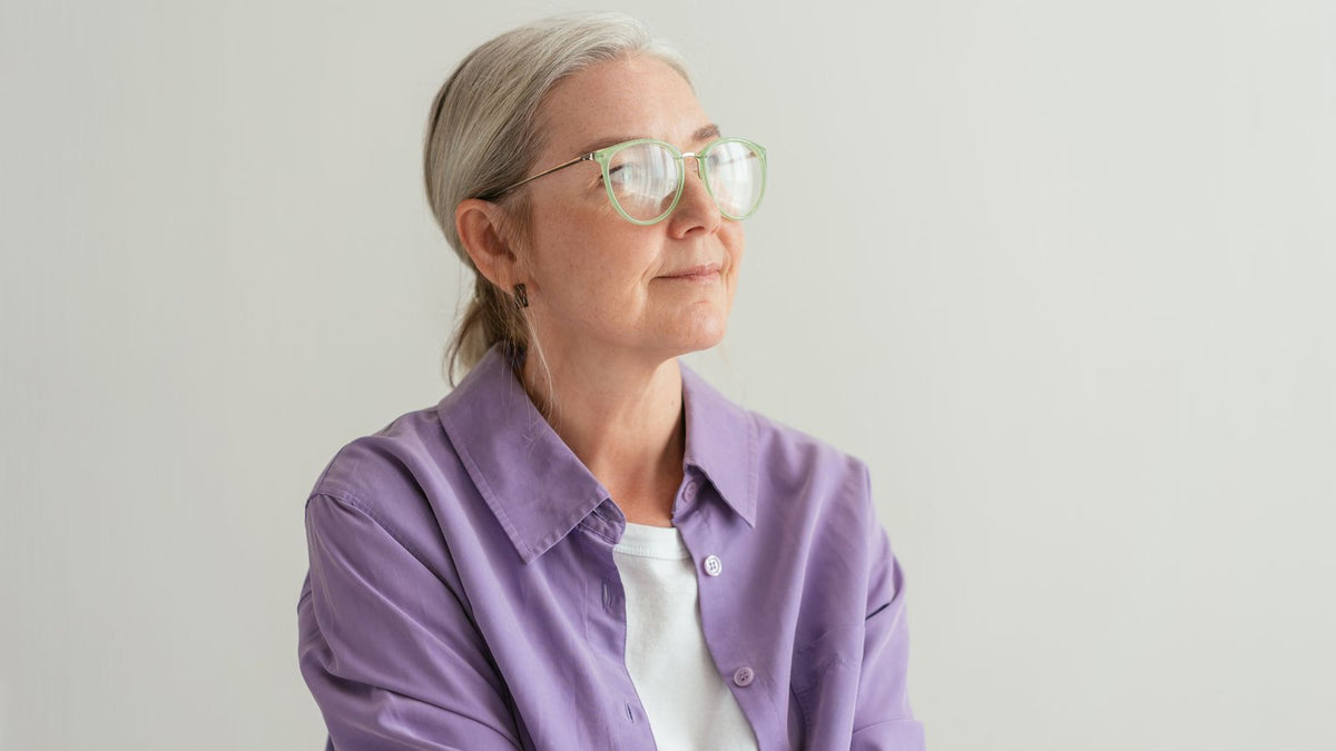Woman in her fifties looking thoughtful, the age group most affected by HRT hair thinning