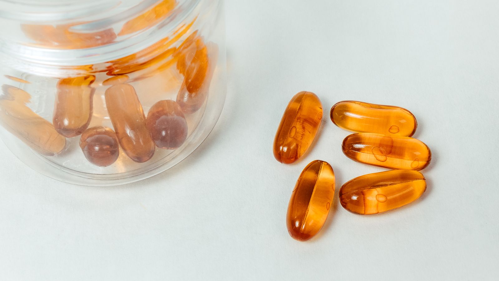 Vitamin capsules spilling from a jar, the question is biotin safe for liver health