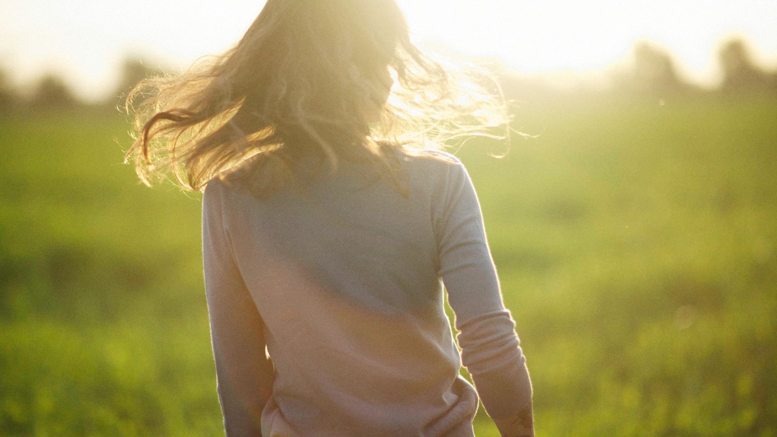 Woman with shiny healthy hair in sunlight, the goal of using lime for hair