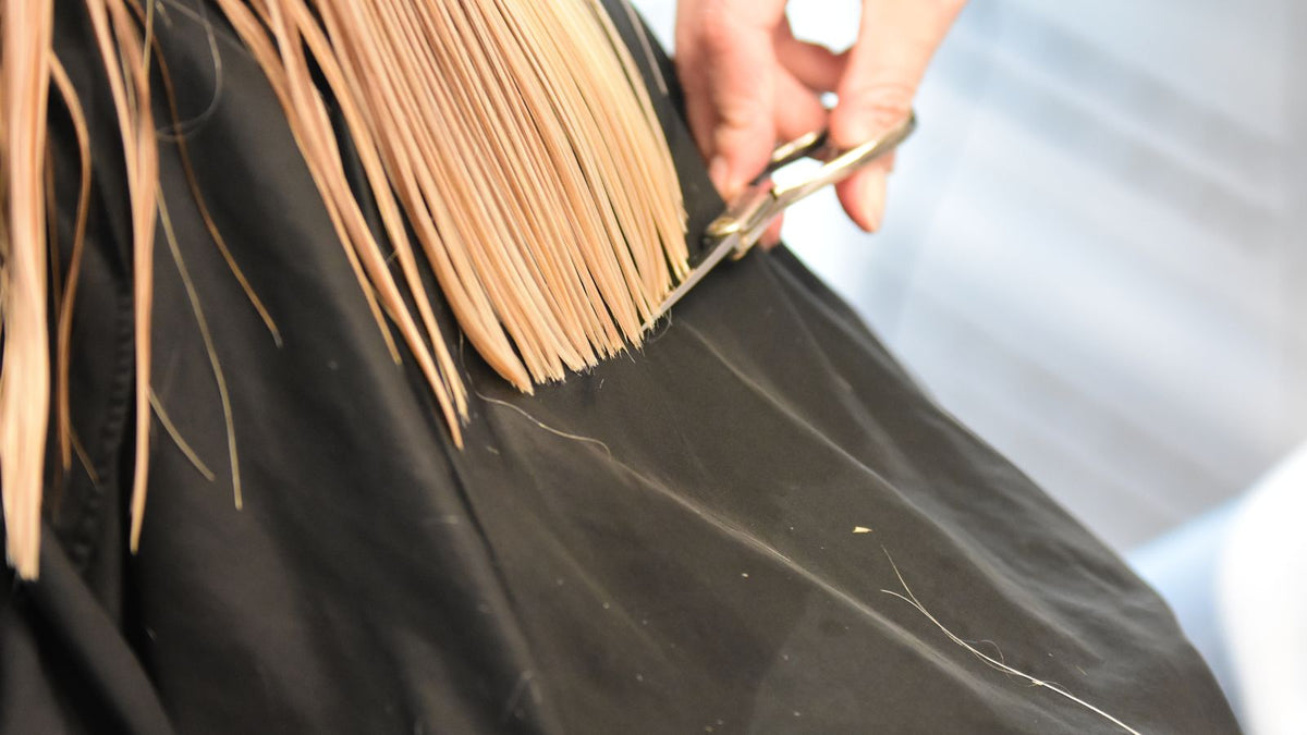 Hairdresser shaping a cut that grows out well, the real answer to how to make hair grow slower