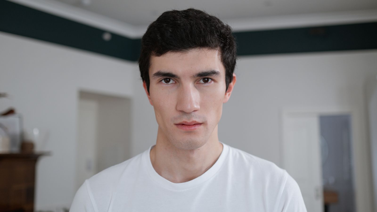 Young man in his twenties looking thoughtful about a mature hairline at 20