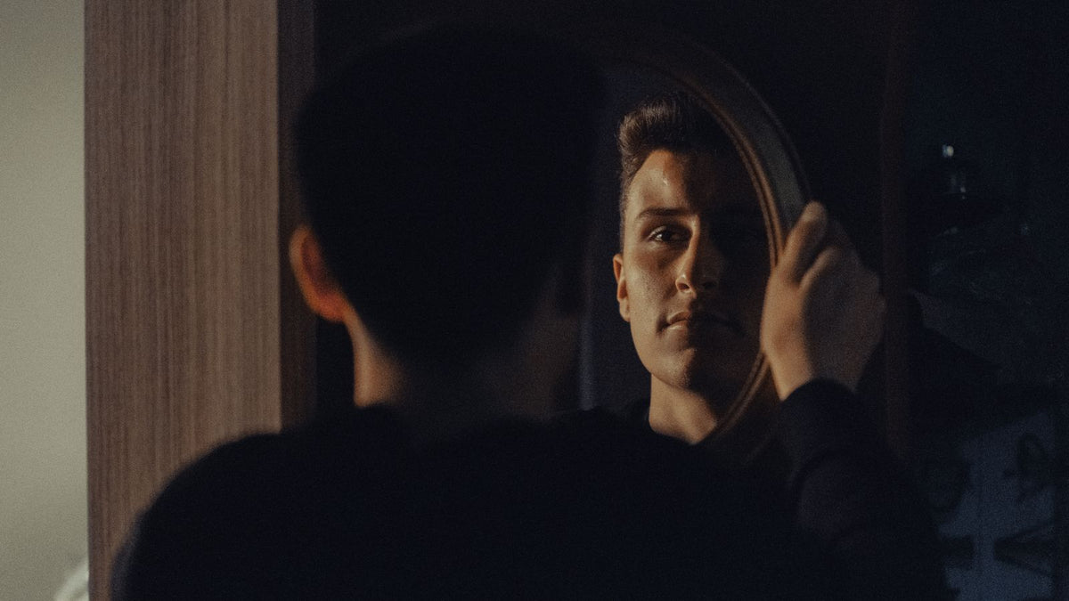 Man studying his reflection to work out mature hairline vs balding