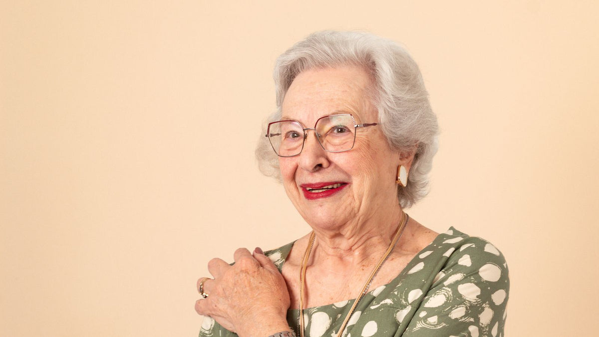 Smiling woman in her fifties with healthy looking hair, choosing menopause hair products