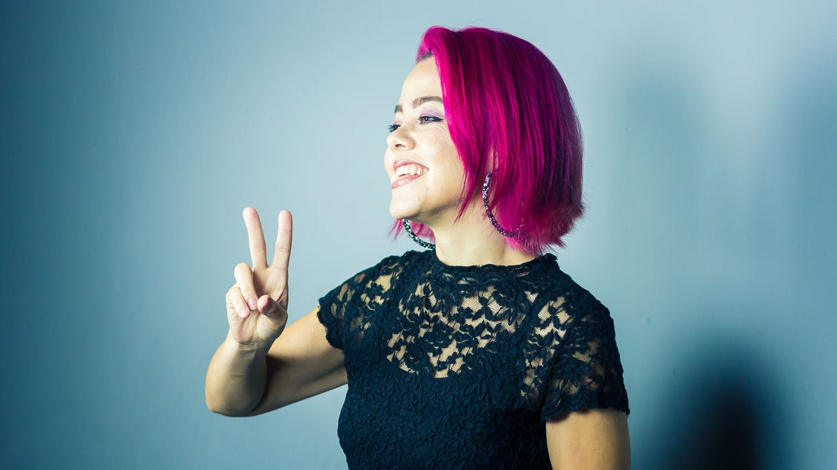 Person with bright pink cropped hair showing nonbinary hair confidence