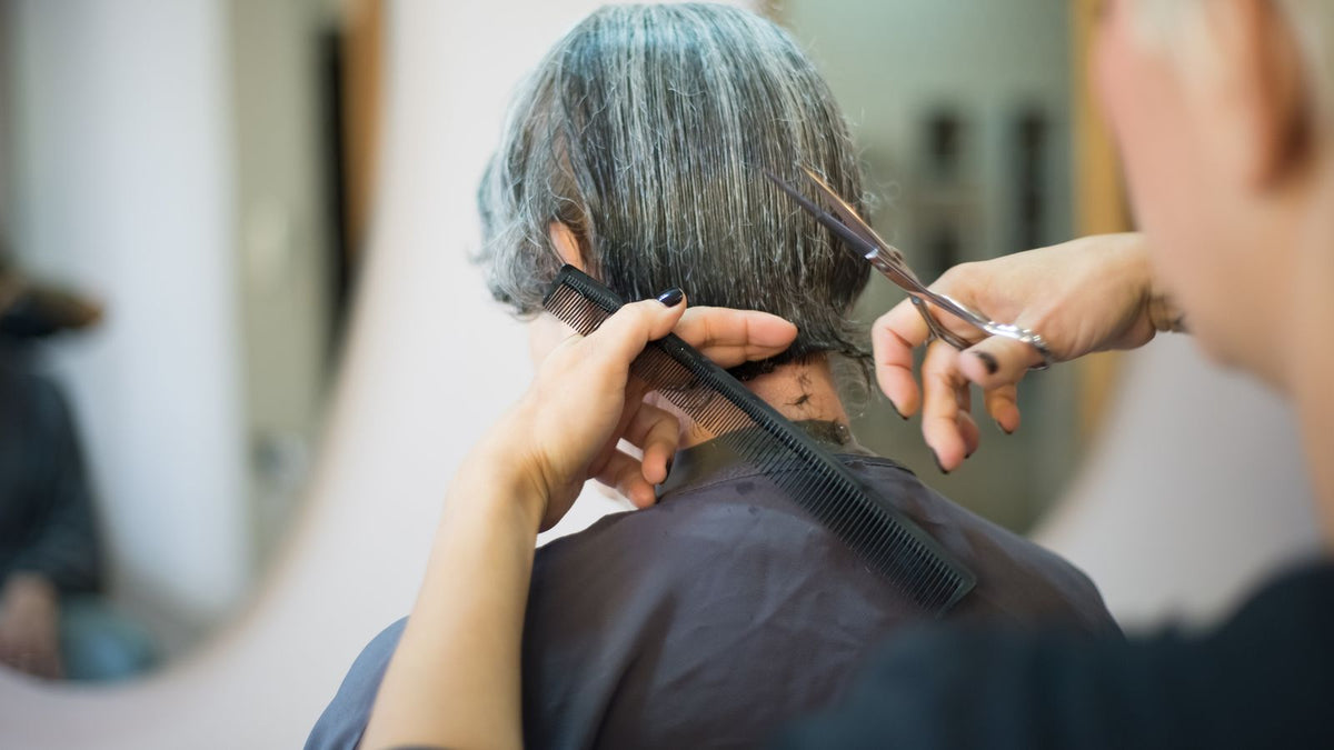 Hairstylist cutting a man's hair, a common moment for spotting norwood scale changes
