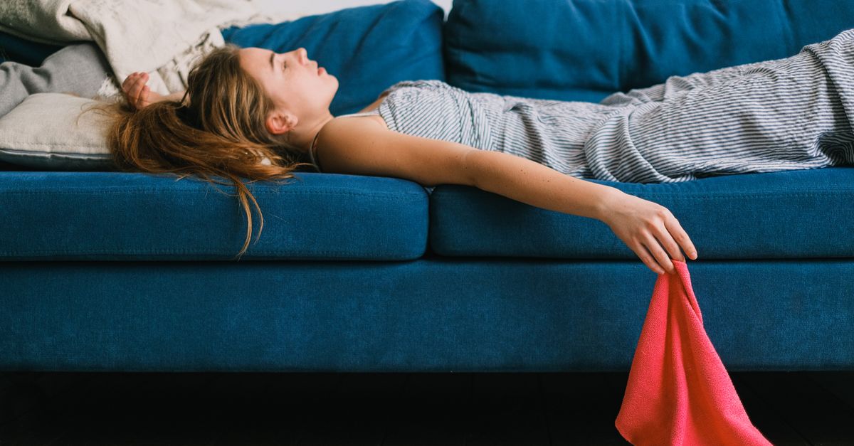 Exhausted woman resting on a sofa, the fatigue that accompanies pica iron deficiency