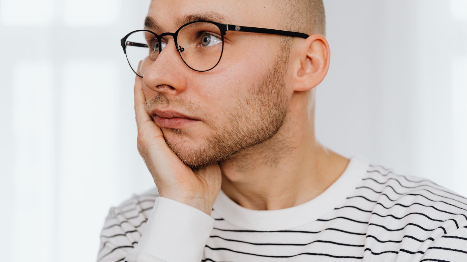 Man looking pensive while considering post finasteride syndrome and hair loss