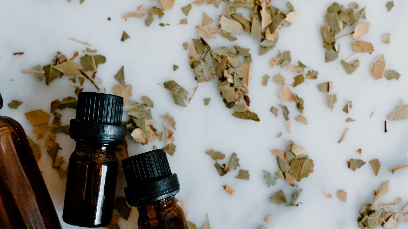 Rosemary and castor oil bottles with herbs for a hair growth blend