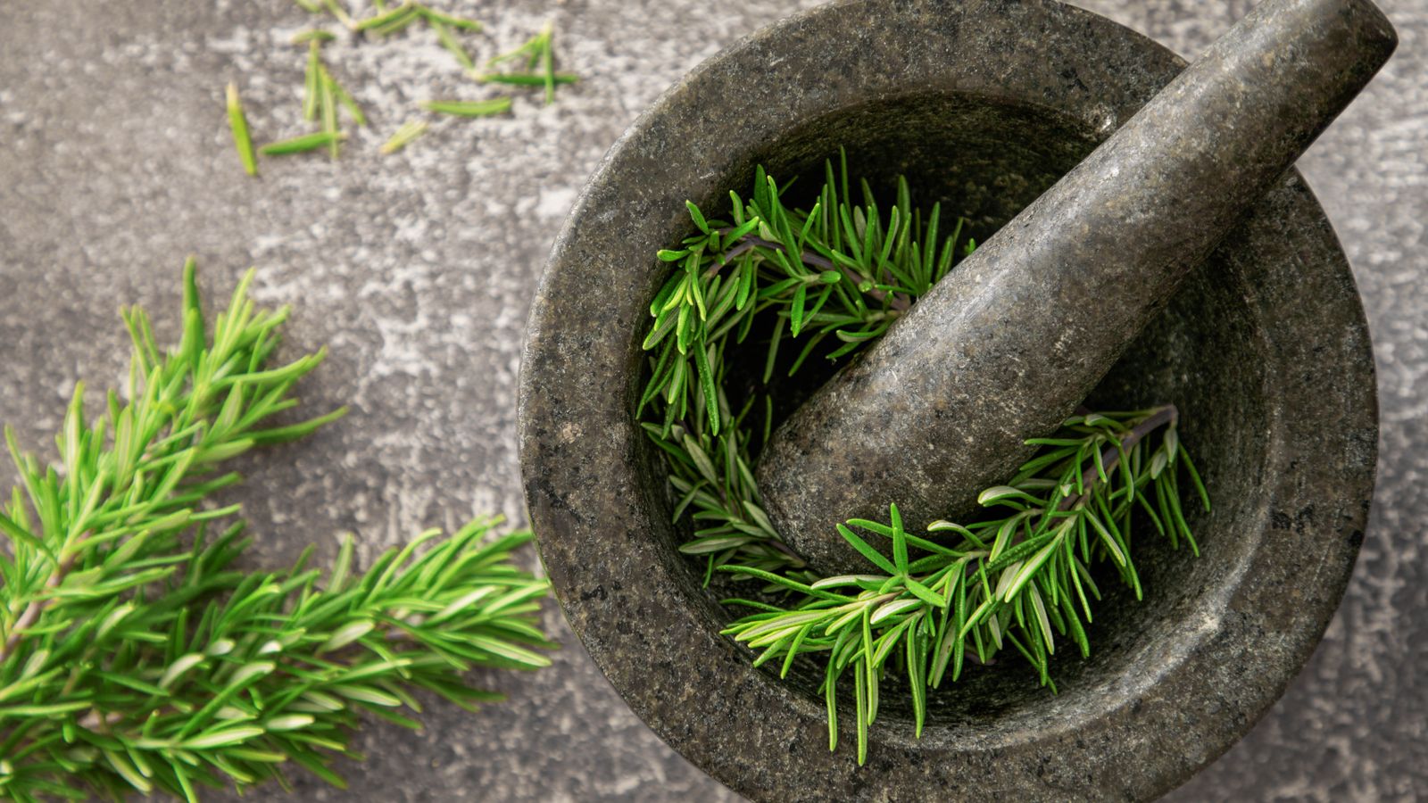 Fresh rosemary in a mortar and pestle, rosemary vs minoxidil for hair growth