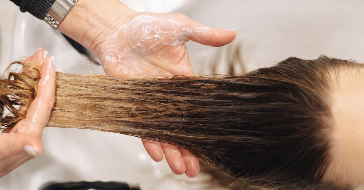 Hands washing hair at a basin, the daily reset for the scalp microbiome
