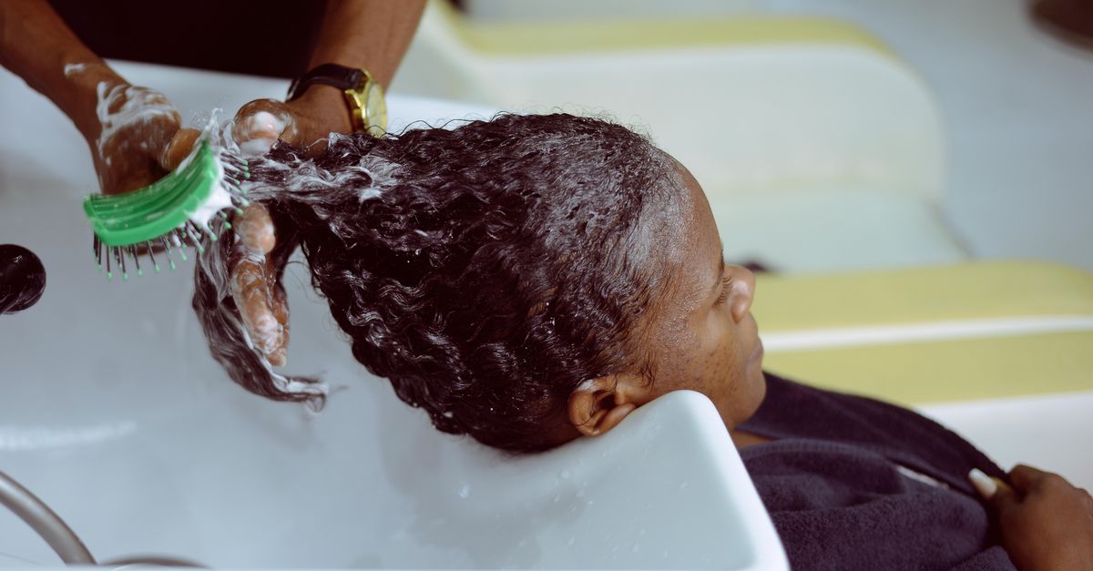 Lathering a shampoo for oily scalp at the roots, where sebum collects between washes