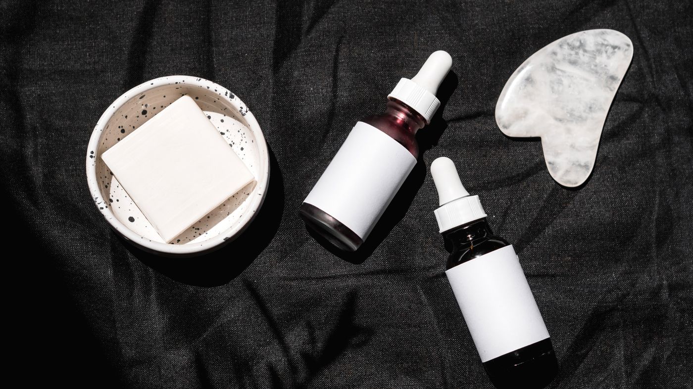 Skincare ingredients that work laid out as serum bottles and jars on a dark surface