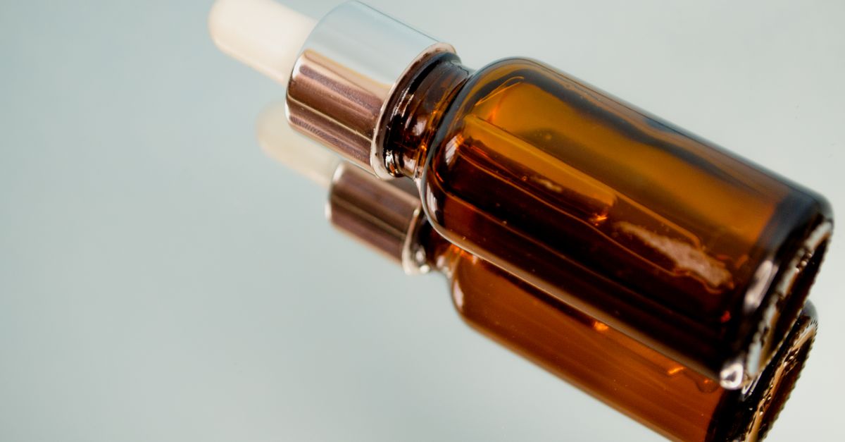 Dropper bottle of a topical hair thinning product on a bathroom surface