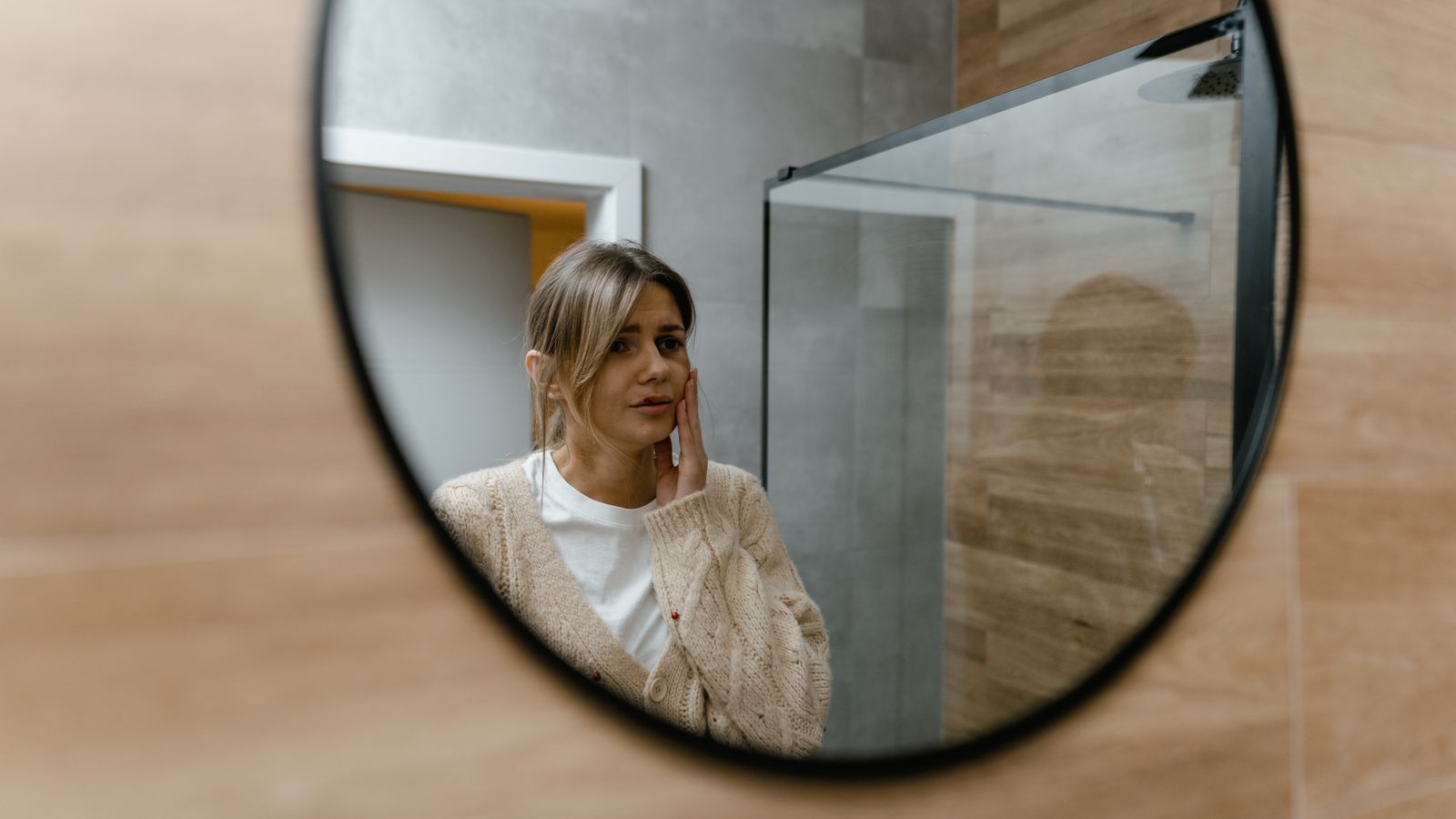 Person checking their hair in a mirror while tracking transgender hair regrowth
