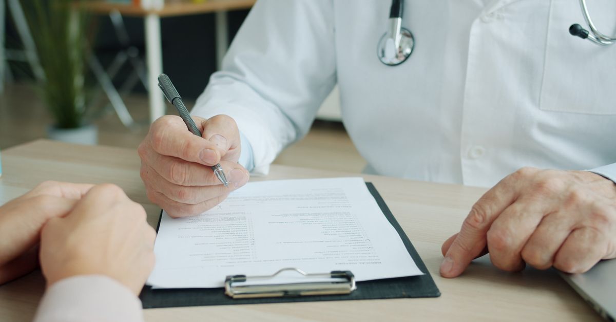 Clinician and client reviewing paperwork together, the consultation a trichologist in Altrincham gives before any treatment