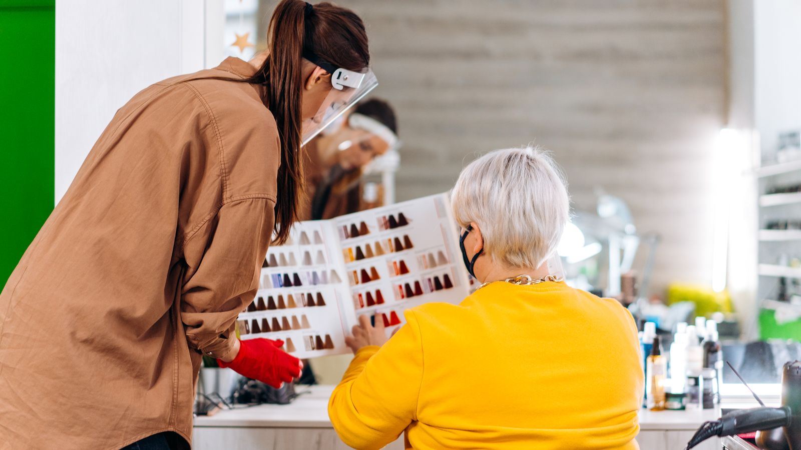 Hair specialist consulting a client at a salon station, similar to booking a trichologist near Dewsbury