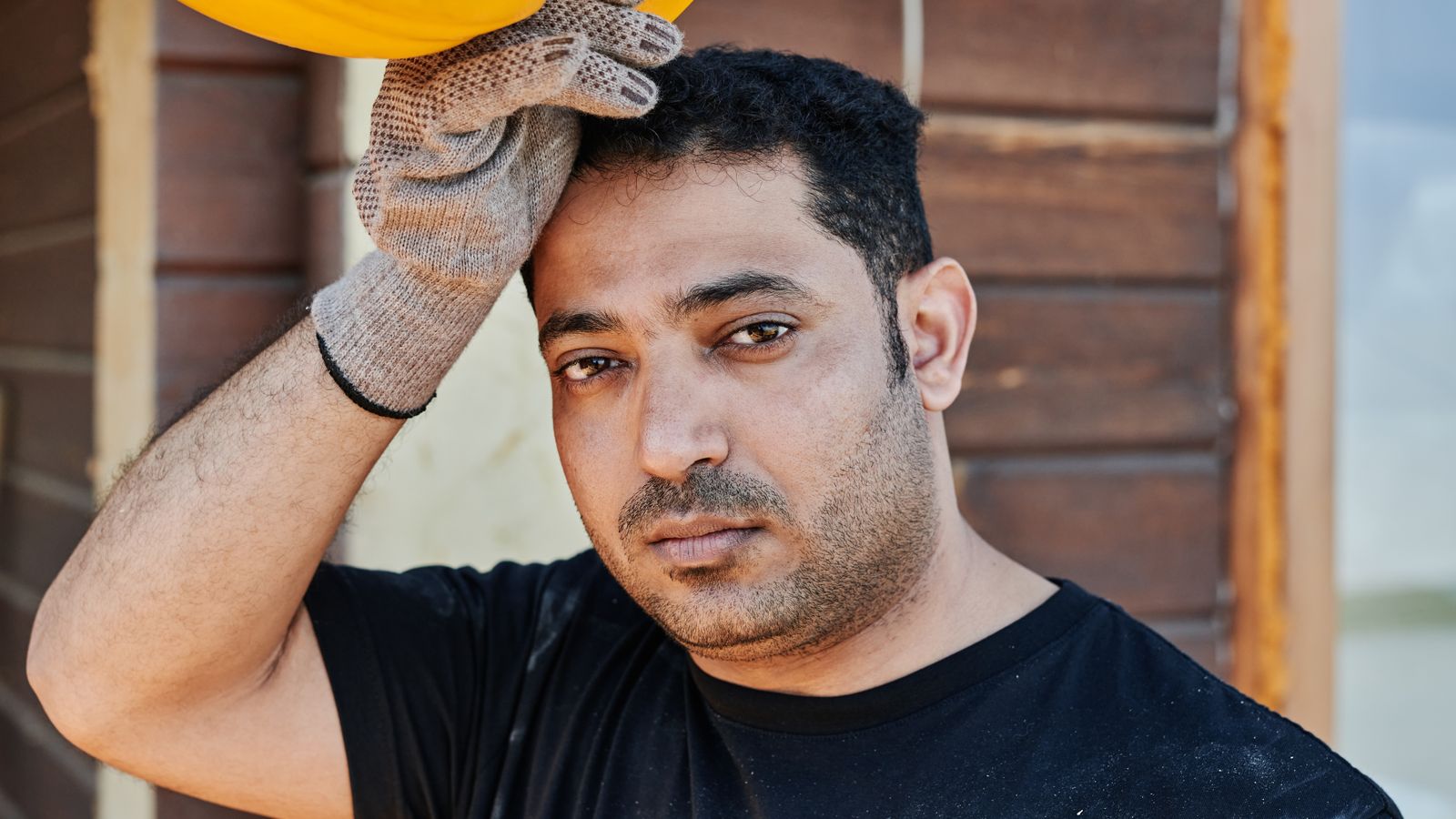Construction worker resting with his hard hat, the kind of daily PPE a trichologist in Goole asks about