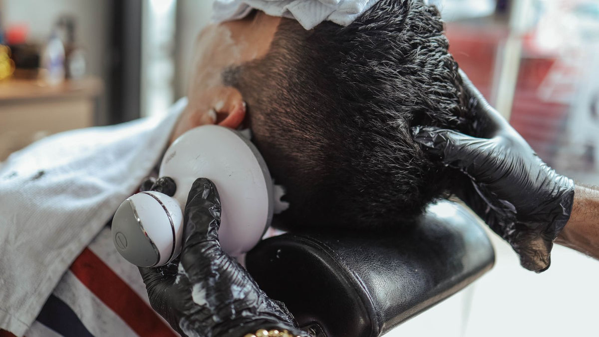 Man having his hair clipped very short, the buzzed look scalp micropigmentation copies, before seeing a trichologist in Harrogate