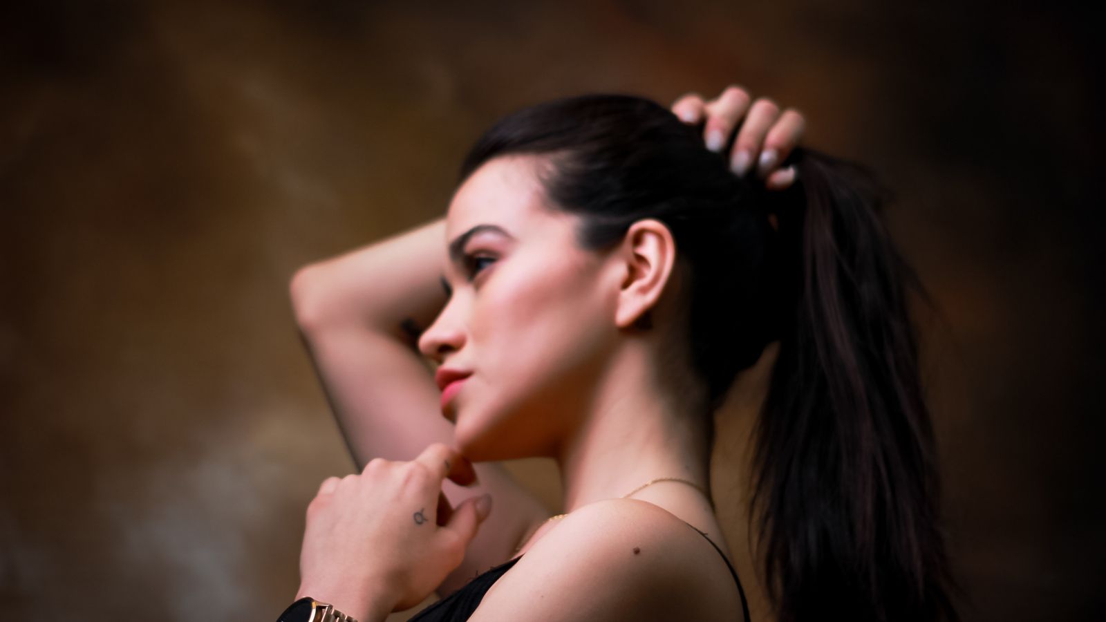 Young woman with her hair pulled back in a tight ponytail, a traction risk a trichologist in Kingston upon Thames sees often