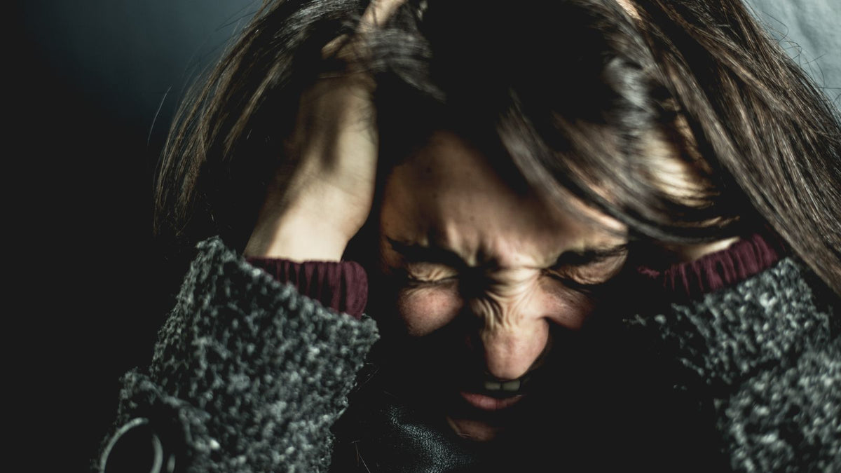Woman with her hands in her hair under stress, the shedding trigger a trichologist in Morpeth hears about most