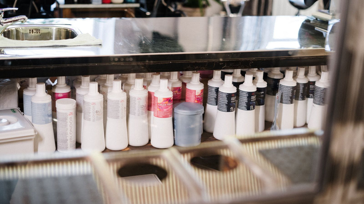 Rows of shampoo and hair care bottles on a salon shelf, the choice anyone searching trichologist St Albans faces when picking a shampoo