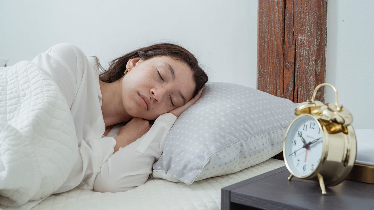 Woman with dark hair asleep on her side on a white pillow, a common reason for one-sided thinning before searching for a trichologist Taunton