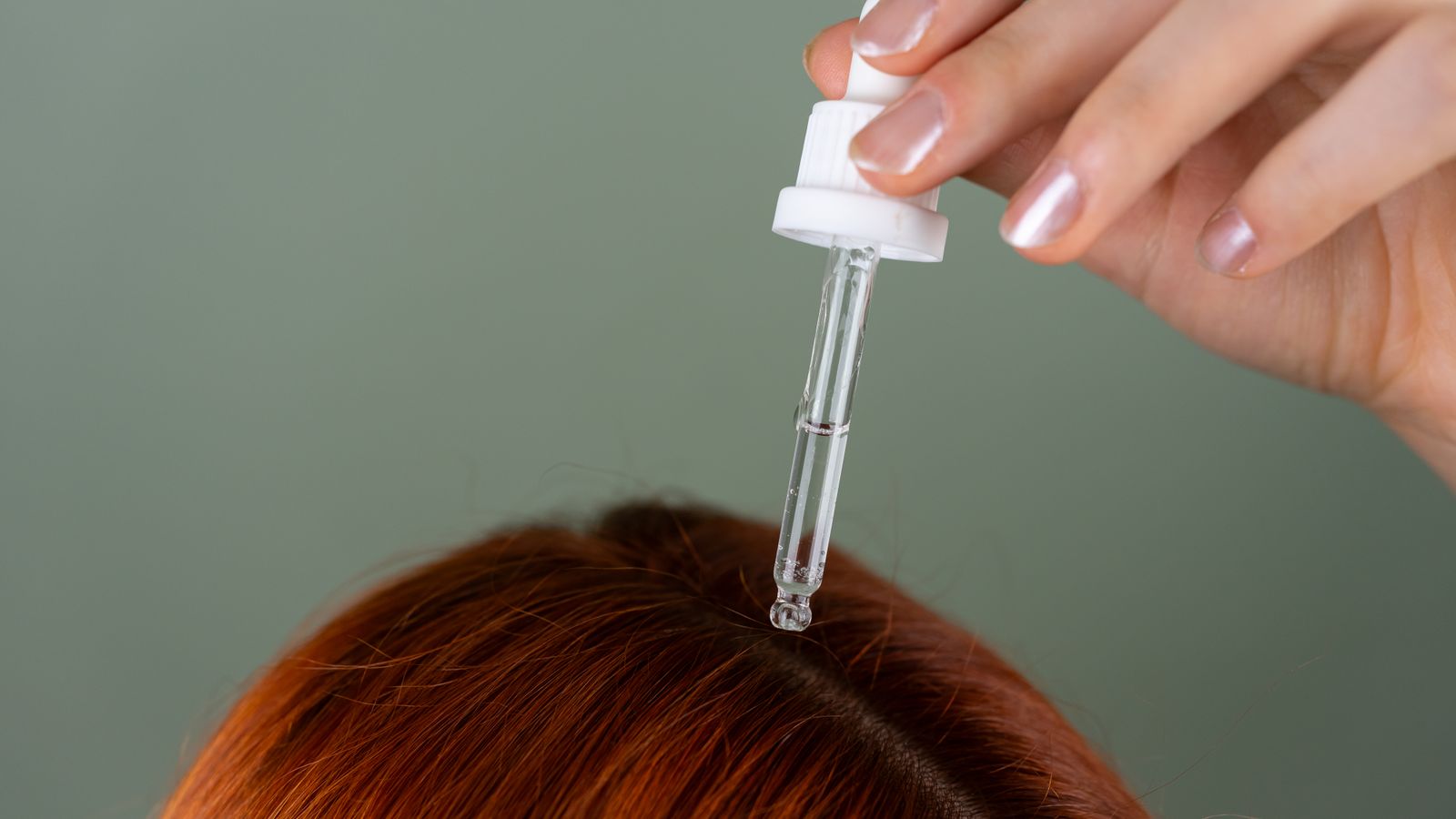Applying a scalp serum to the roots with a dropper, the kind of routine a trichologist in Twickenham may advise
