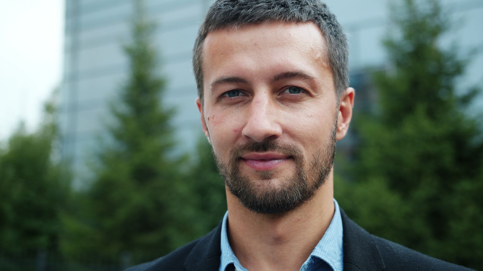 Confident man outdoors, managing a visible scalp through thinning hair