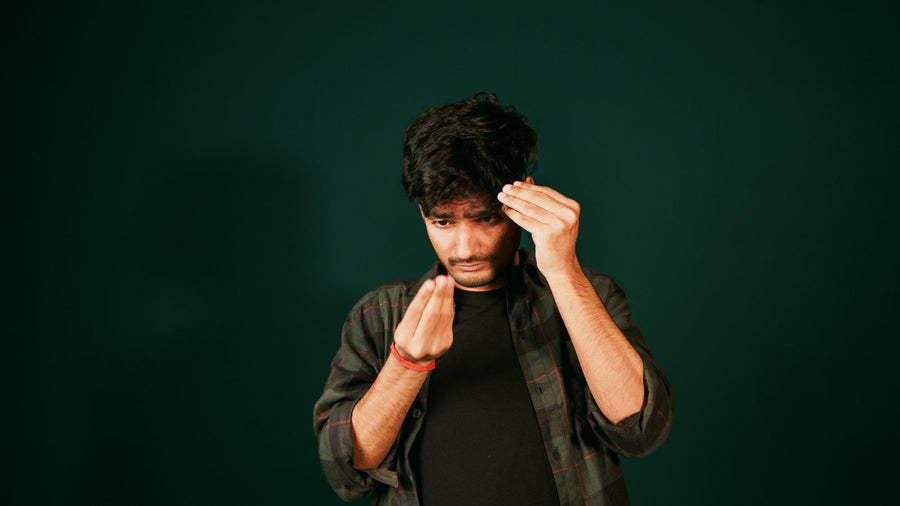 Young man examining his hairline in a mirror for signs of new hair growth
