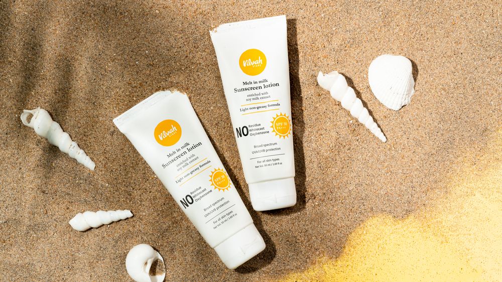 Affordable sunscreen tubes on sand, showing budget sun protection options