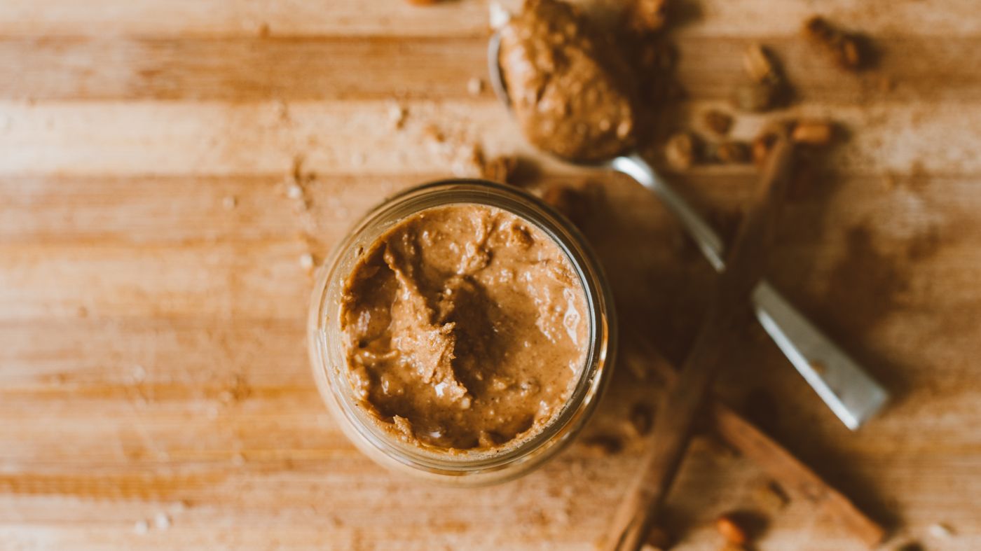 Jar of peanut butter with a spoon, the food most often linked to aflatoxins in peanut butter