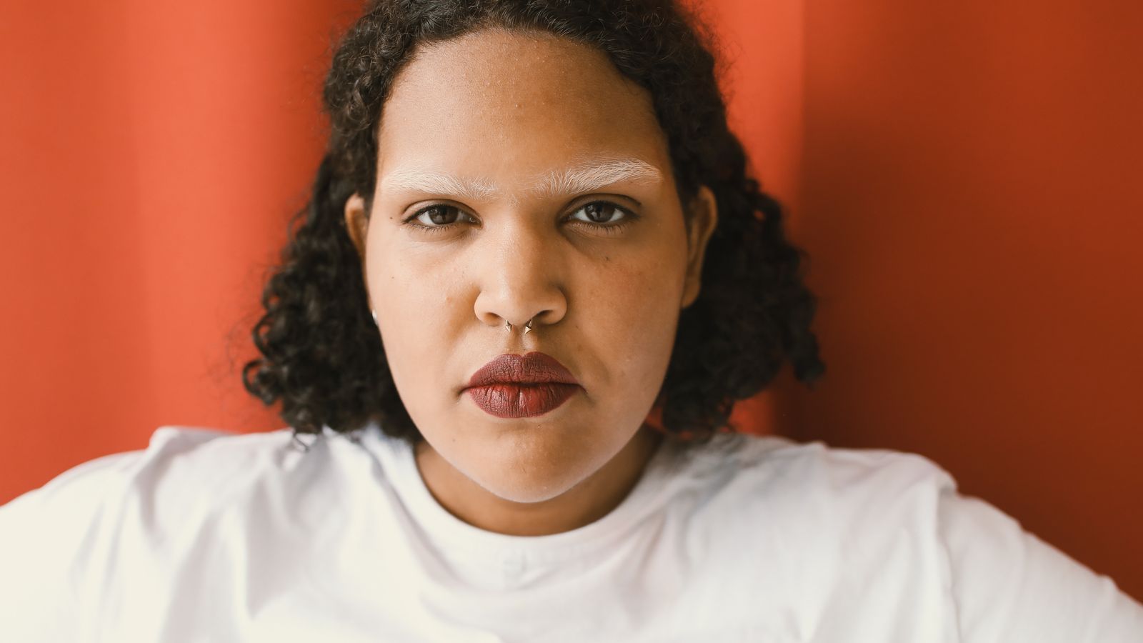 Androgenetic alopecia trans women experience: a woman with curly hair looking directly at the camera