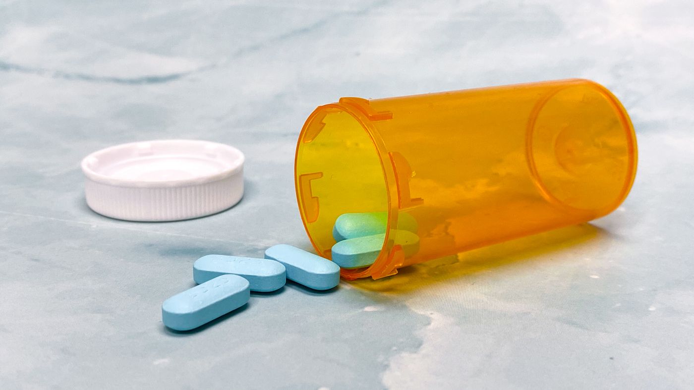 Prescription tablets spilling from a bottle, representing antiandrogen therapy medicines