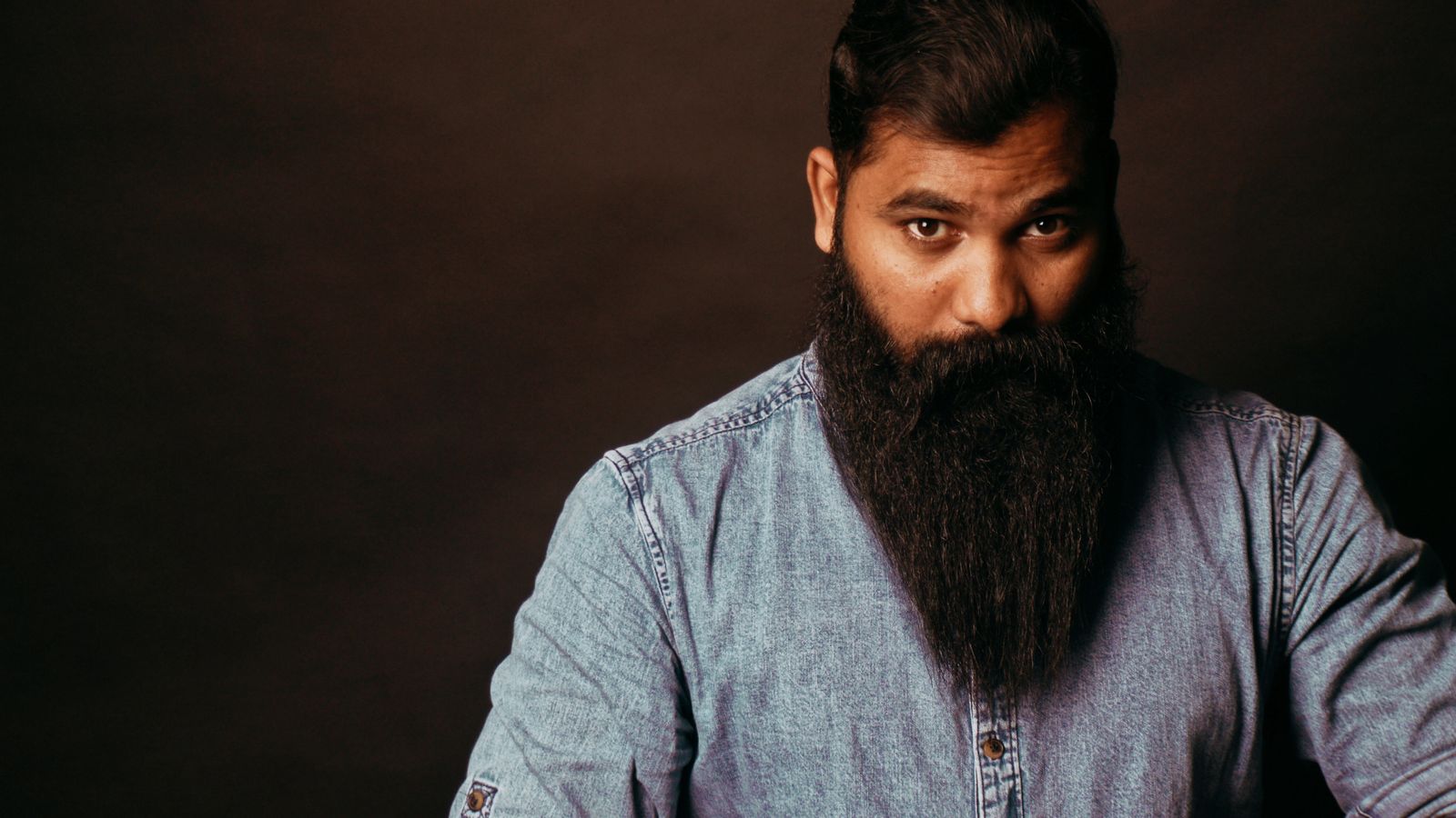 Bearded man in a denim shirt, illustrating beard growth on testosterone