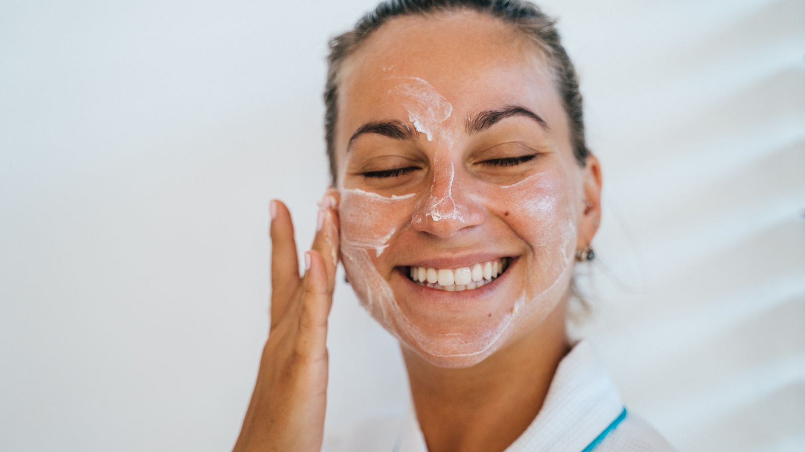 Woman applying a lightweight face cream, choosing the best moisturiser for oily skin