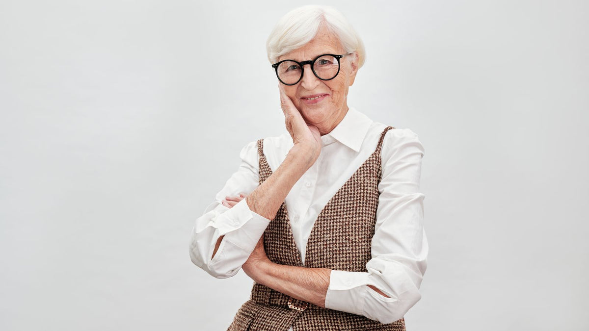 Smiling woman in her sixties with silver hair reading about bioidentical HRT